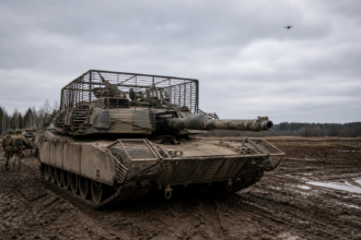 M1-Abrams-Kampfpanzer mit Drohnenschutz auf einem schlammigen Übungsplatz [Bildinhalt mit KI erstellt]